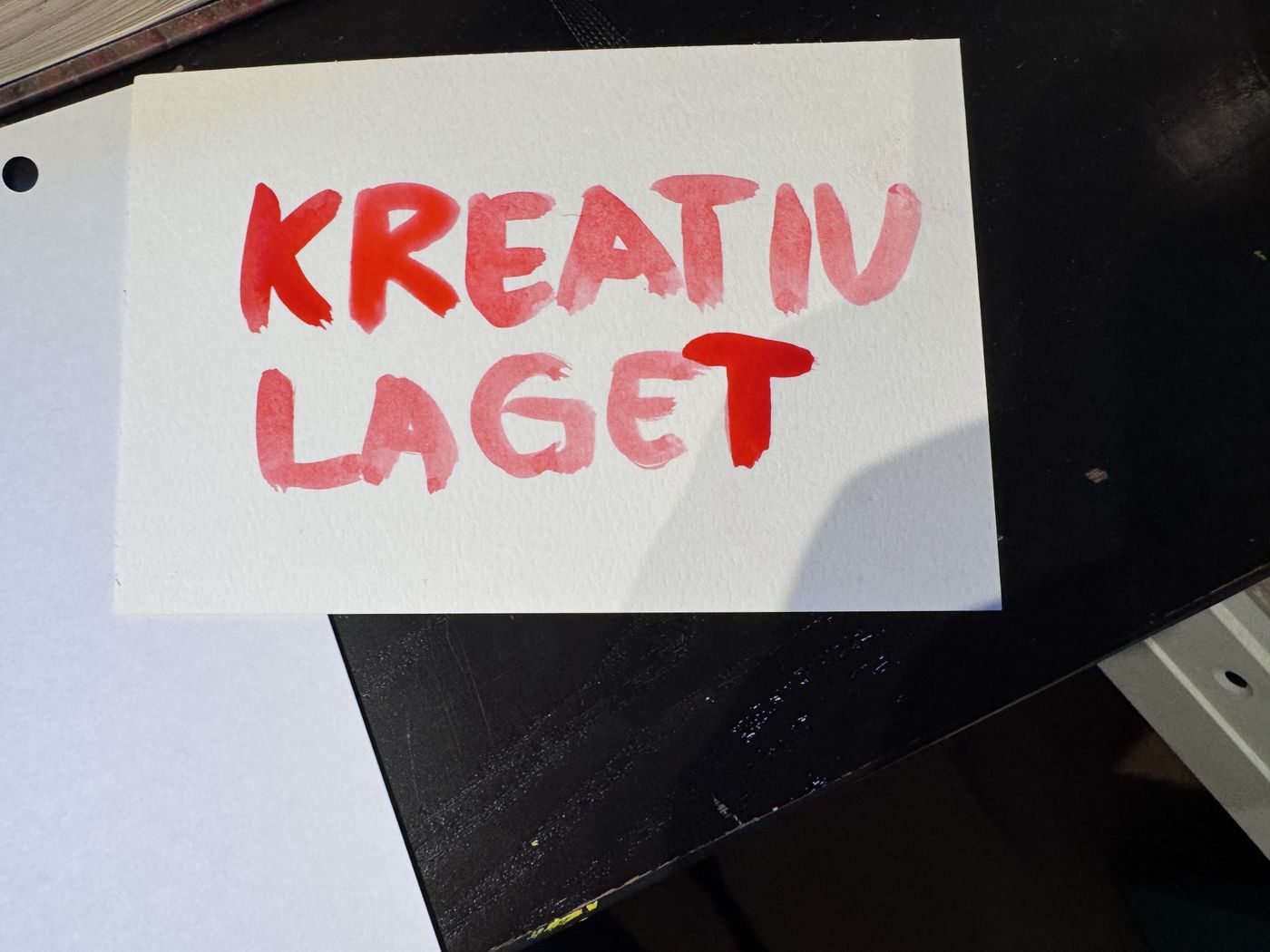 Håndmalt skilt med teksten Kreativ laget i rødt